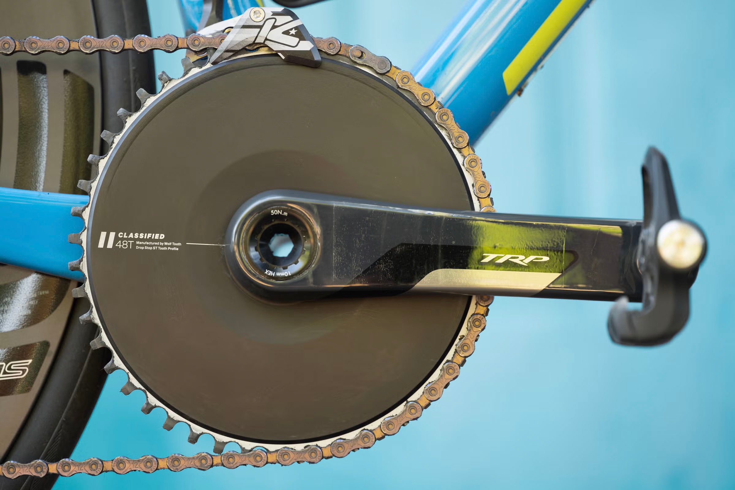 Close-up of a bicycle with TRP crankset with chain and gear on a blue background