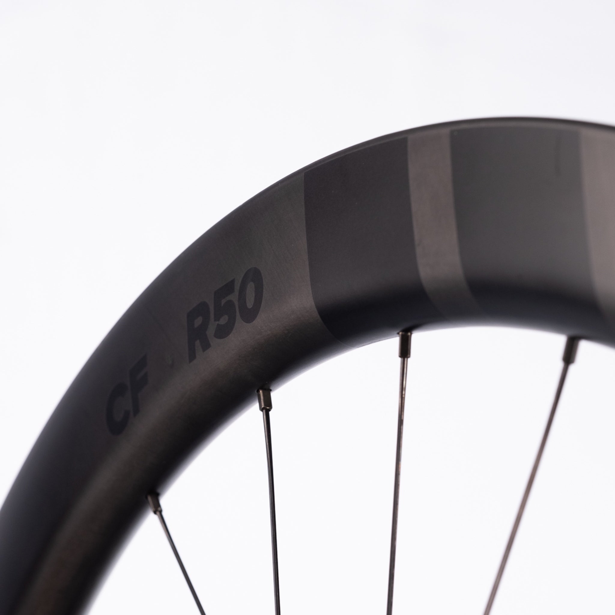 Close-up of a black bicycle wheel with 'Clasified R50' branding on a white background