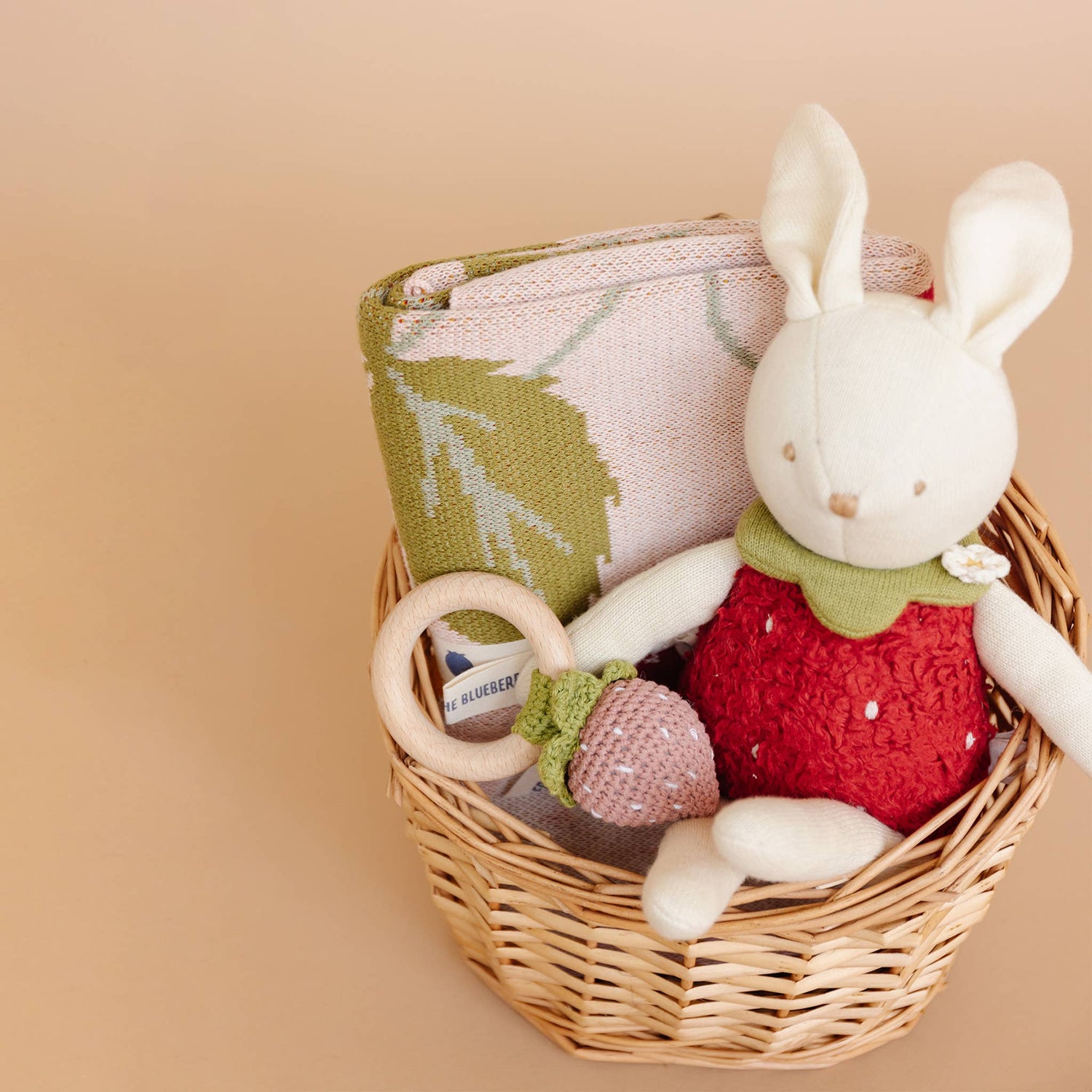 Gift basket with The Blueberry Hill Strawberry Bunny blanket, bunny plush toy, and baby rattle
