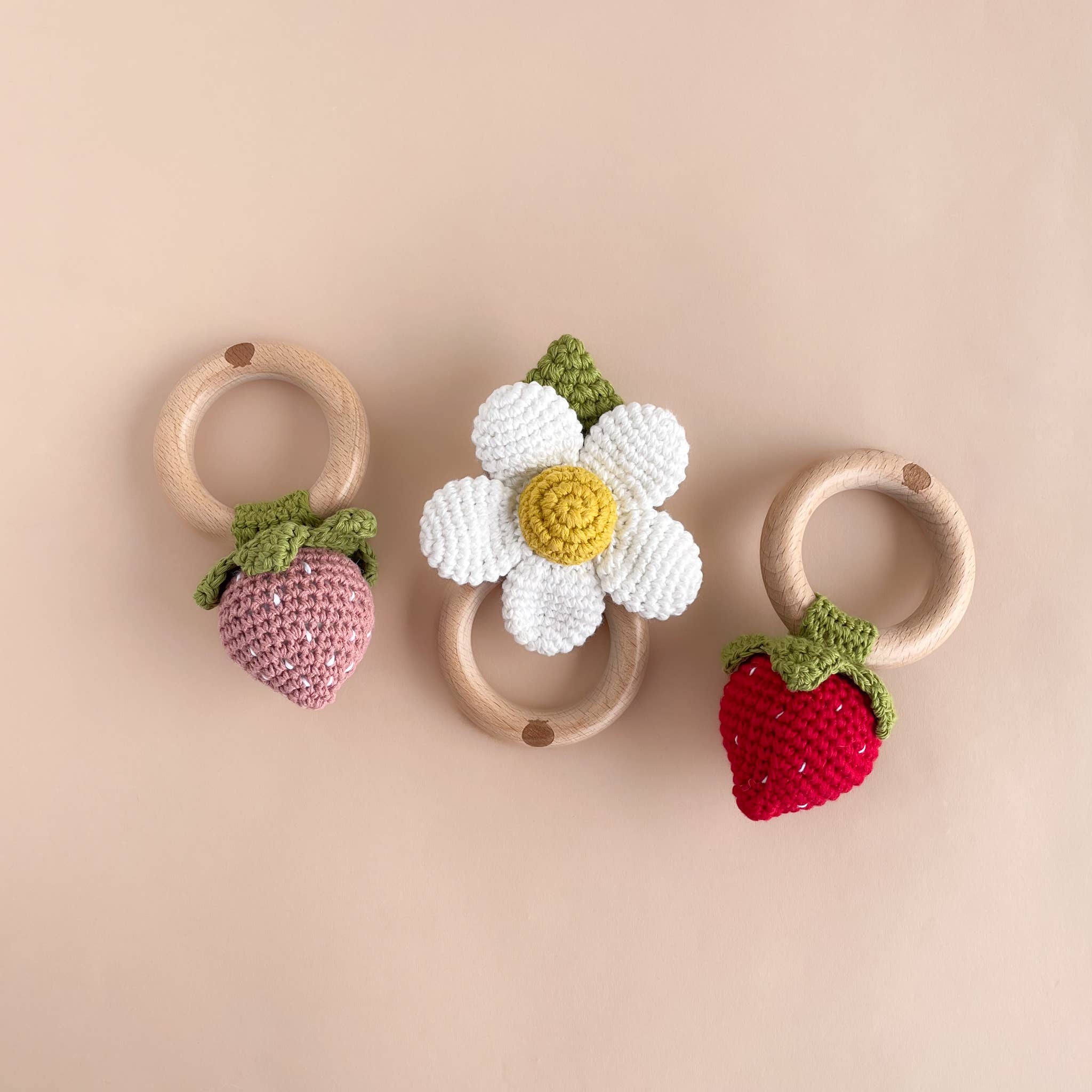The Blueberry Hill crochet baby teethers with strawberry and flower designs
